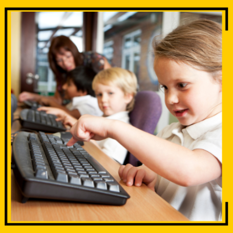 Children's services worker showing a boy and a girl how to use a computer.